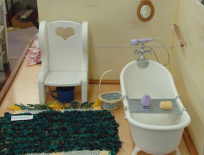 Clawfoot bathtub, chair, rug all doll-sized.