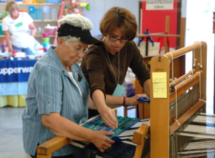 Helping a woman with rug weaving.