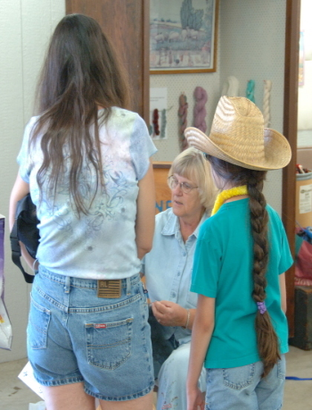 Girl in cowboy hat watching spinning.