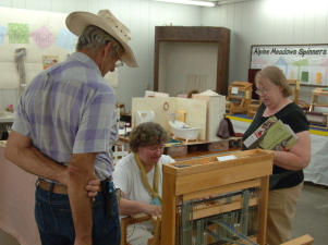 Demonstrating weaving on small floor loom.