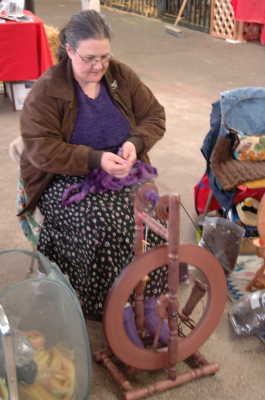 Spinner spinning lavender roving on castle wheel.