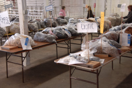 Bags of fleece on tables including mohair, alpaca, llama.